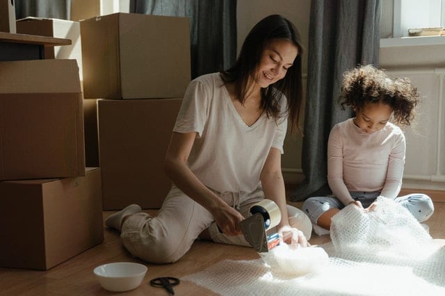 A woman and a girl trying to pack fragile items when moving.